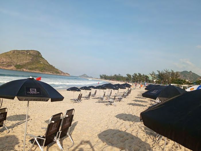 Beach Point do CDesign Hotel na areia da Praia do Recreio, com espreguiçadeiras e guarda-sóis